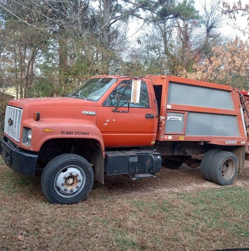 Old Cleveland Disposal garbage truck parked on a route in Habersham County, Georgia